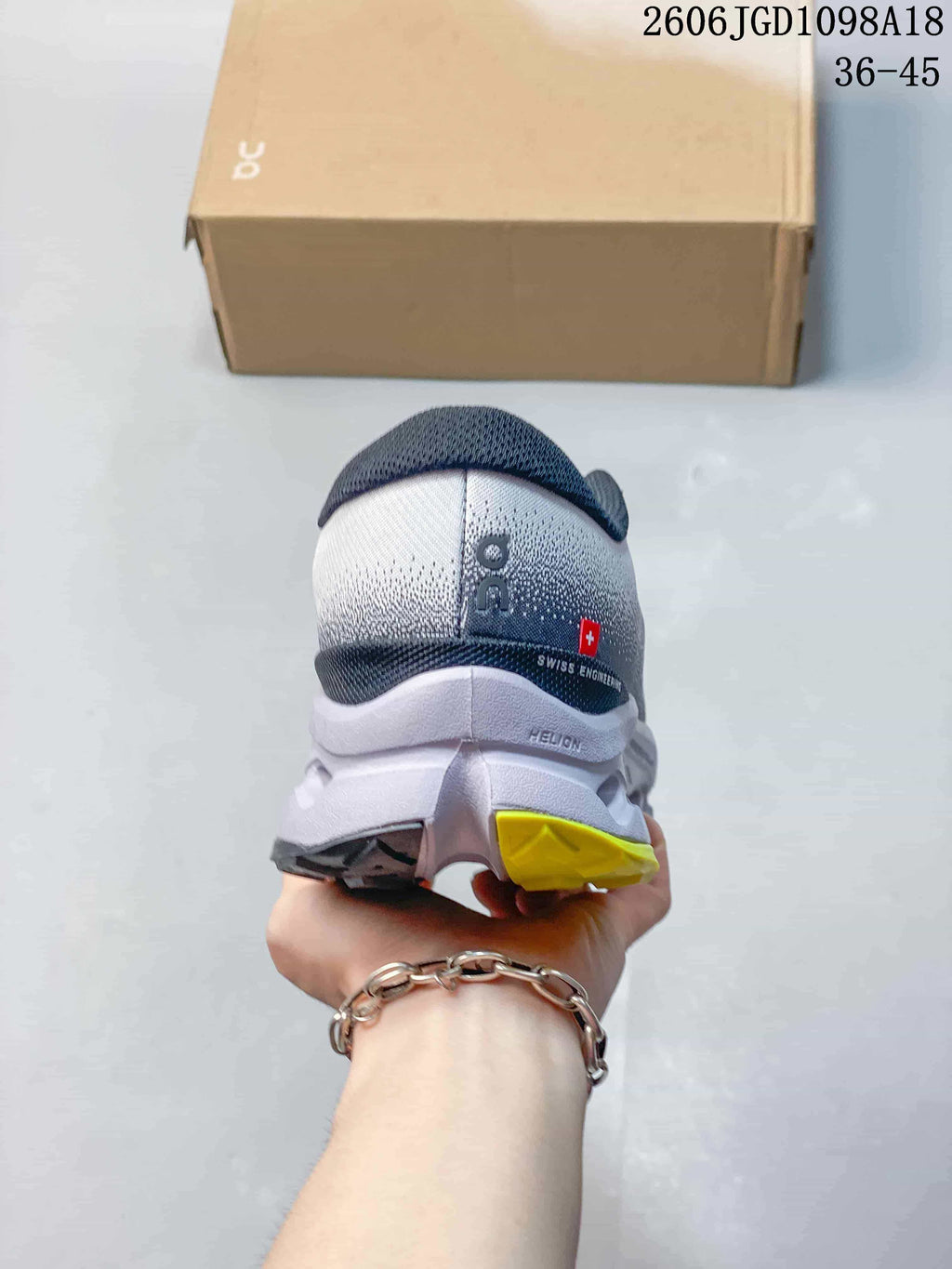 Rear view of the shoe showing its gray upper, sculpted sole and yellow outsole detail