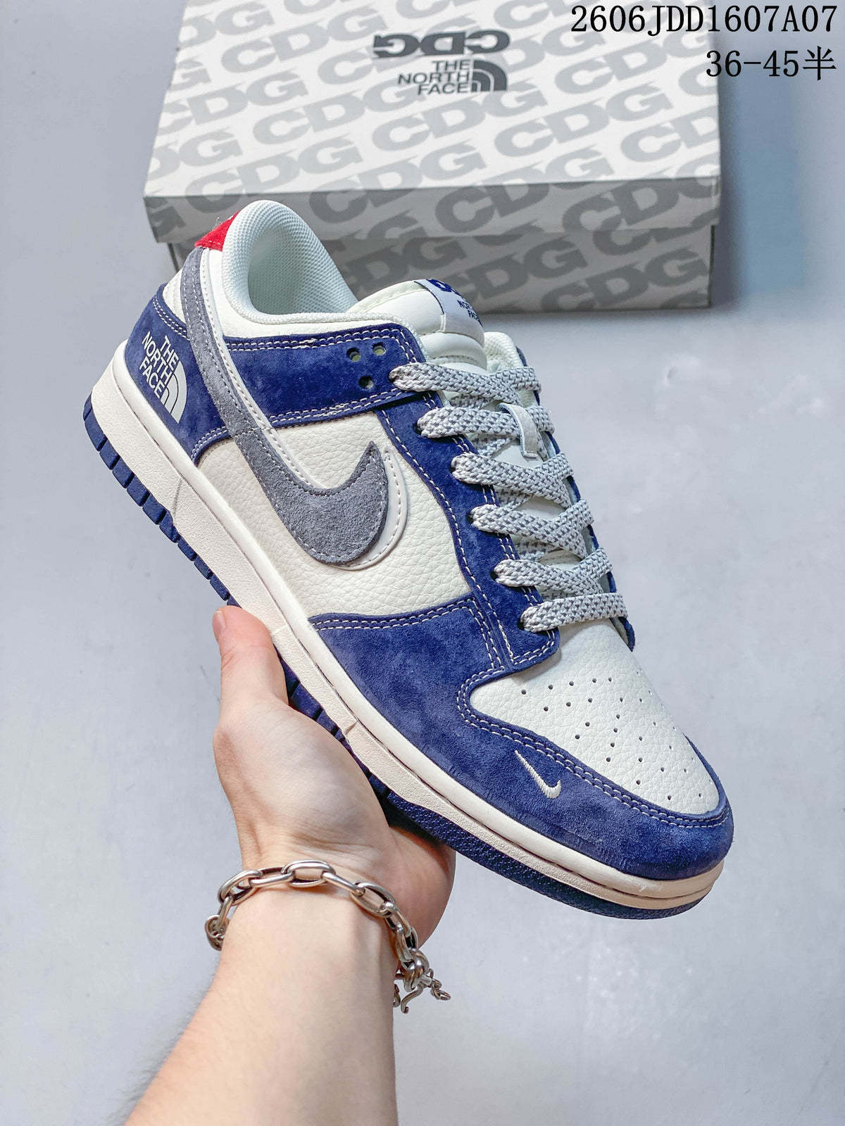Angled view of a blue and white sneaker with gray side Swoosh and red heel tab