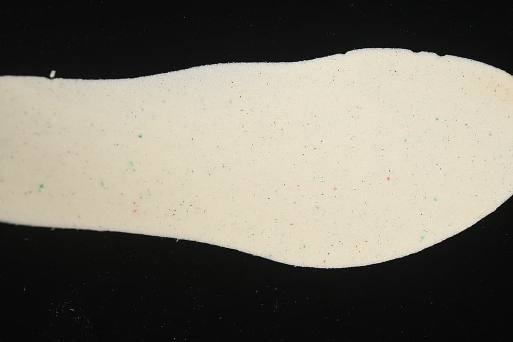 Light-colored shoe insole shown against a black background