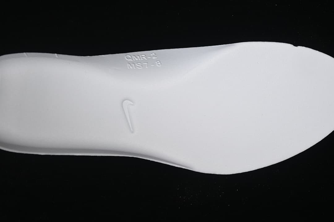 White shoe insert showing an embossed Nike Swoosh.