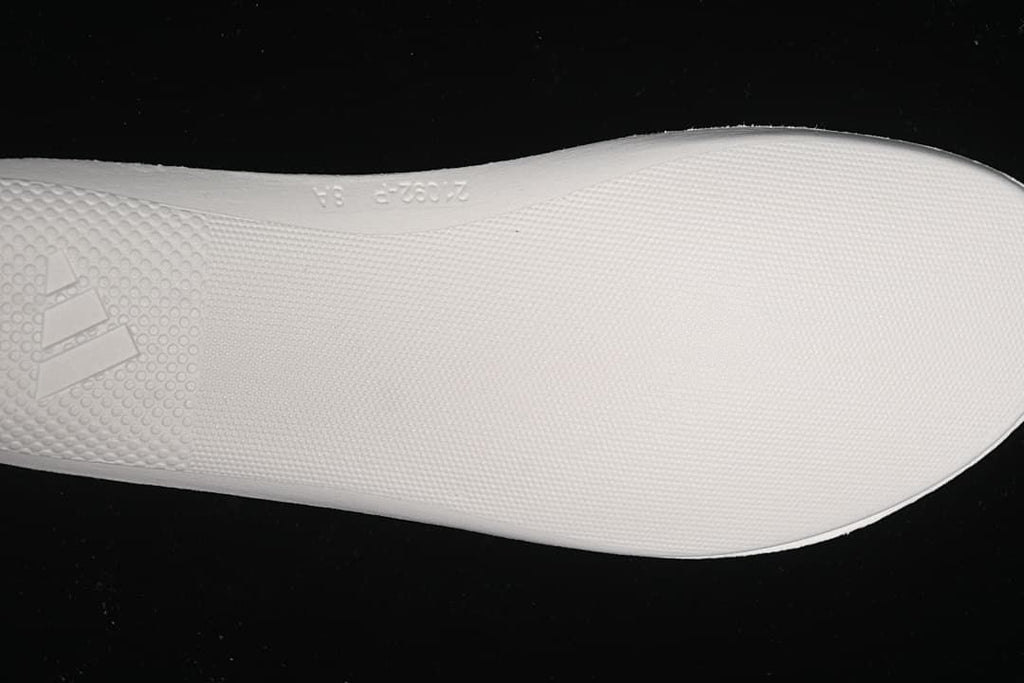 Close-up of the white textured outsole and Adidas branding.