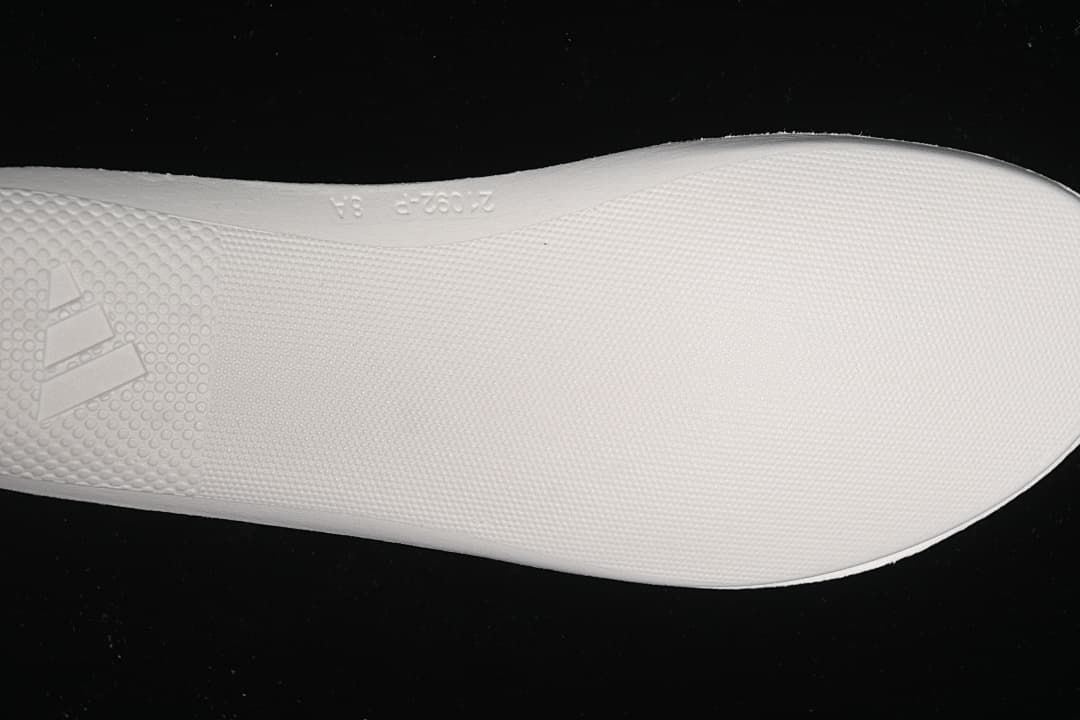 Close-up of the white textured outsole and Adidas branding.