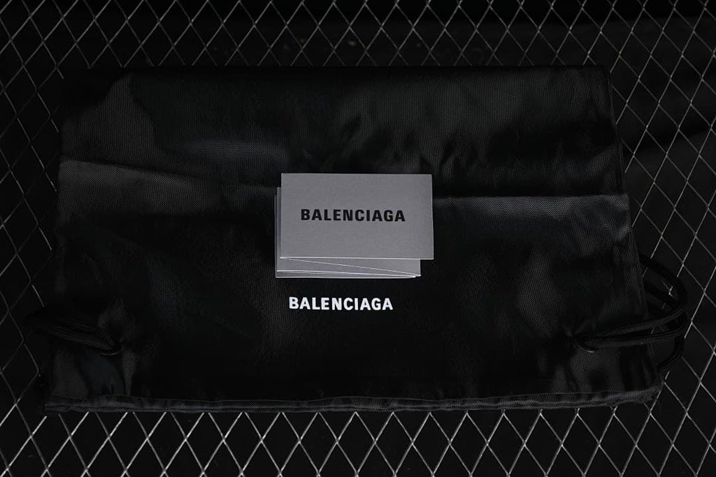 Black branded shoe dust bag and card displayed on a dark background