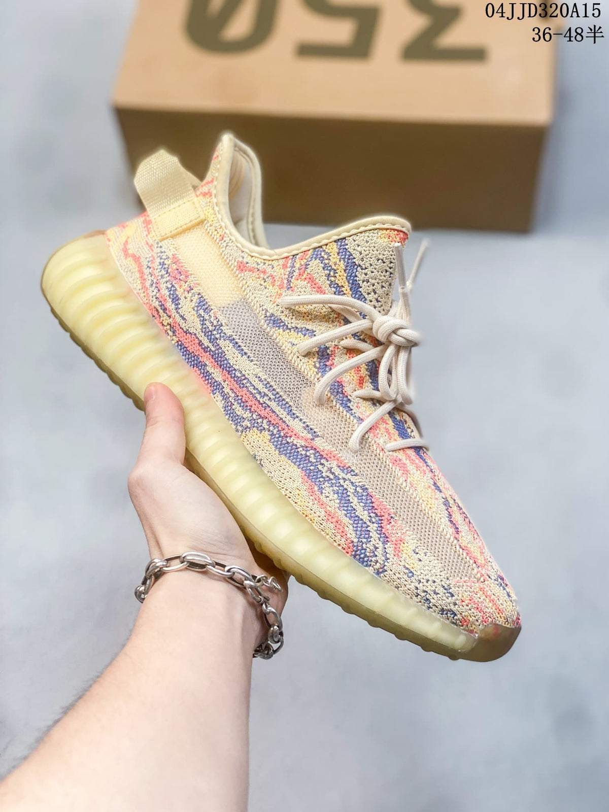 Side view of a cream Yeezy Boost 350-style sneaker with multicolor knit pattern and ribbed pale sole.