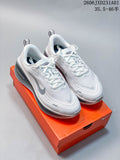 Pair of white and gray Nike Vomero Plus running shoes shown on an orange box.