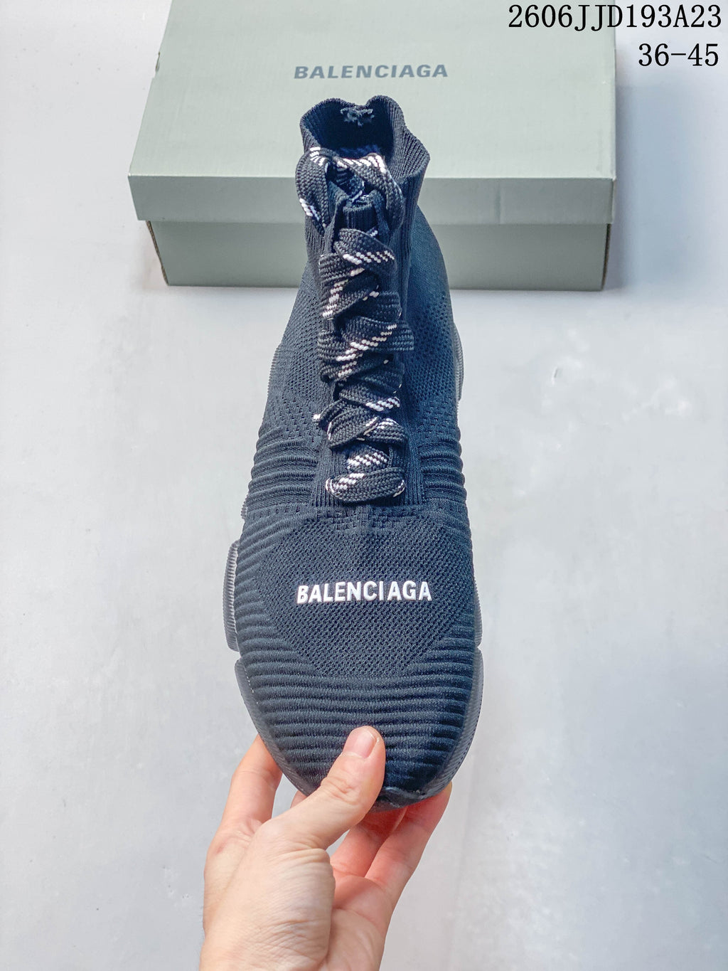 Front view of a navy high-cut sneaker with contrast laces and Balenciaga lettering