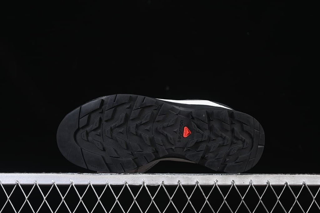 Underside view showing the black lugged outsole and red Salomon detail.