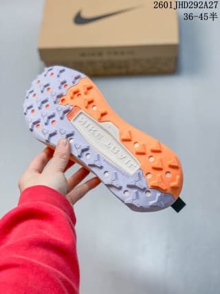 Underside view showing the shoe's white, orange, and purple-toned lugged outsole.