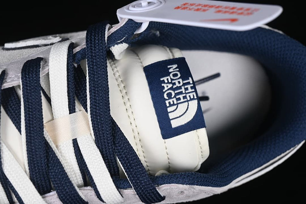 Close-up of the tongue label and alternating navy and white laces.