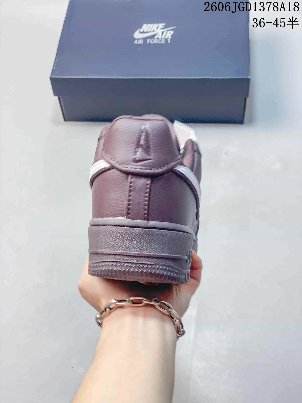 Rear view of a mauve low-top sneaker with a layered heel and padded collar.
