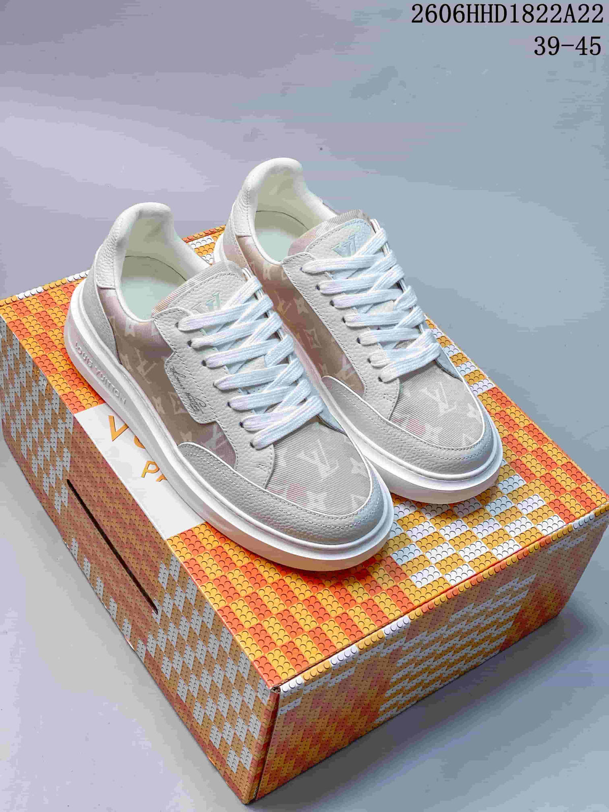 Pair of light-colored Louis Vuitton Beverly Hills low-top lace-up sneakers on a patterned box