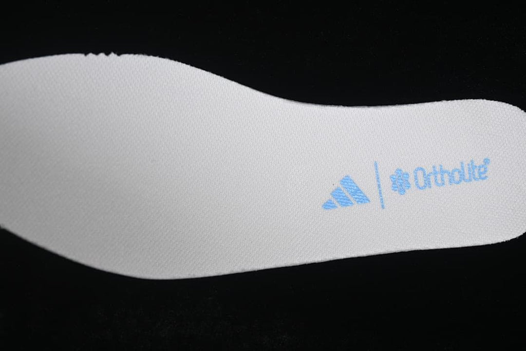 Close view of a white shoe insert with blue adidas and Ortholite markings.
