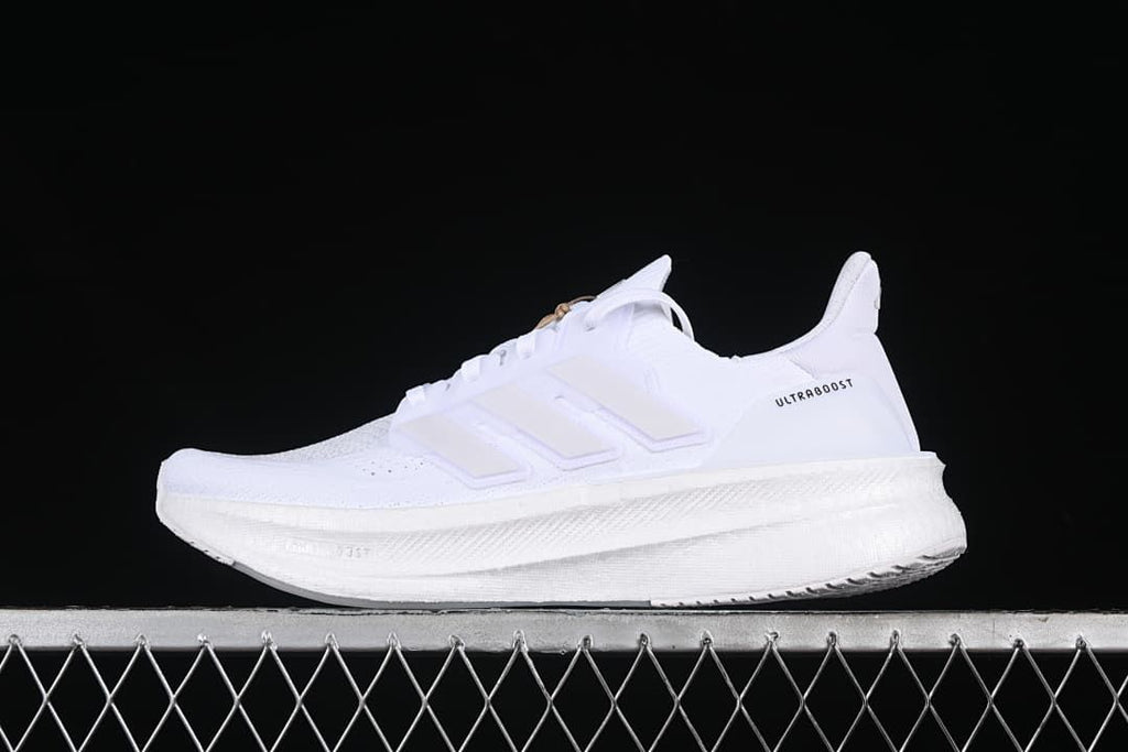 Side view of a white Adidas Ultraboost 5 shoe against a dark background.