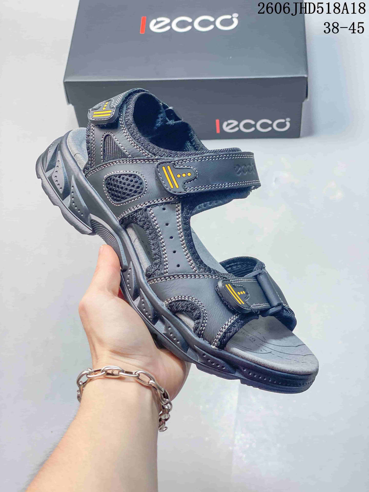 Angled view of the gray sandal with yellow strap accents
