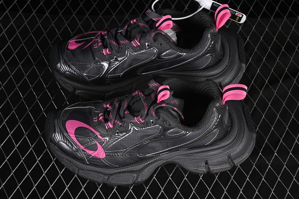 Pair of dark grey and pink sneakers shown from above.