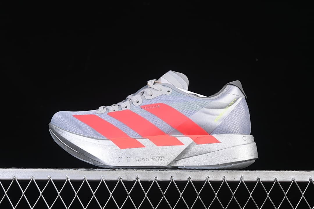 Side view of gray Adidas Adizero Adios Pro 4 running shoe with coral stripes