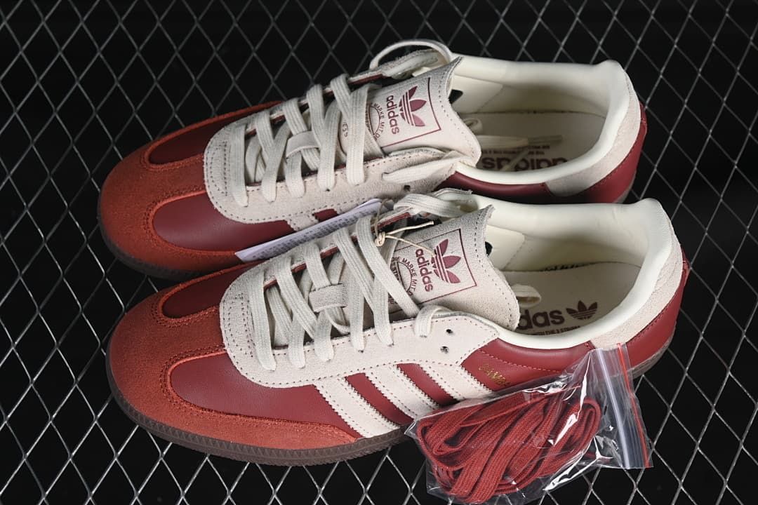 Pair of burgundy and cream Samba OG sneakers with an extra set of laces
