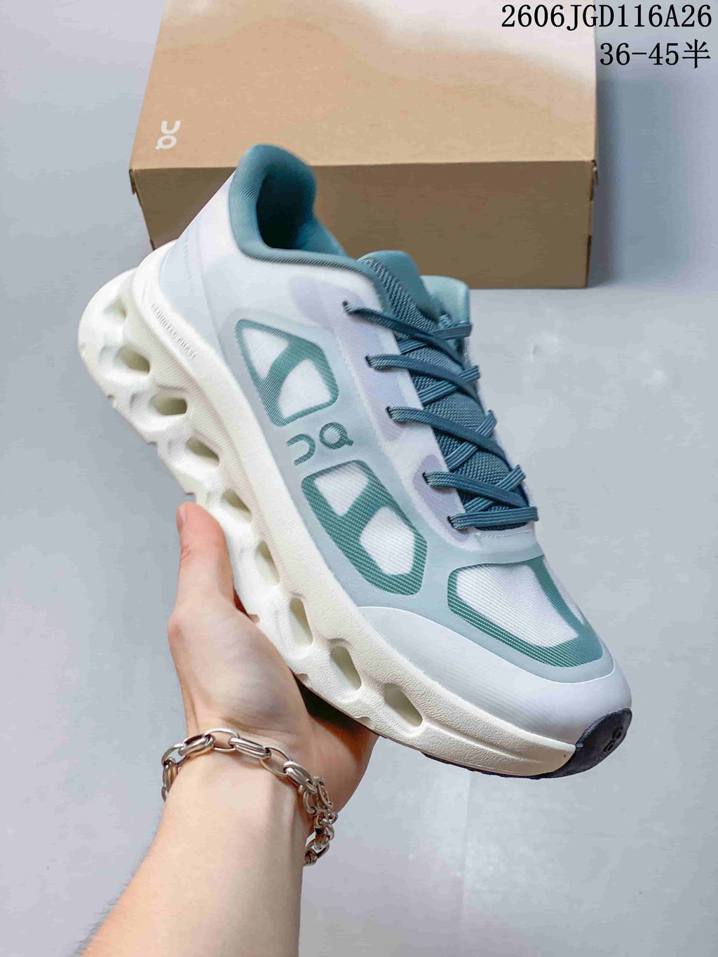 Close-up side view of a white On Cloudtilt Remix sneaker with teal accents and a sculpted sole.