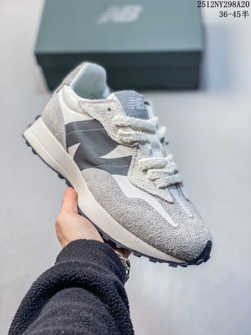 Angled side view of a gray and navy New Balance 327-style sneaker