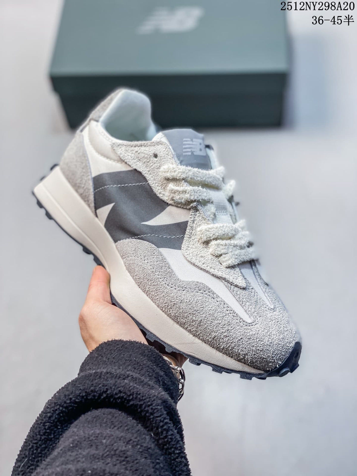 Angled side view of a gray and navy New Balance 327-style sneaker
