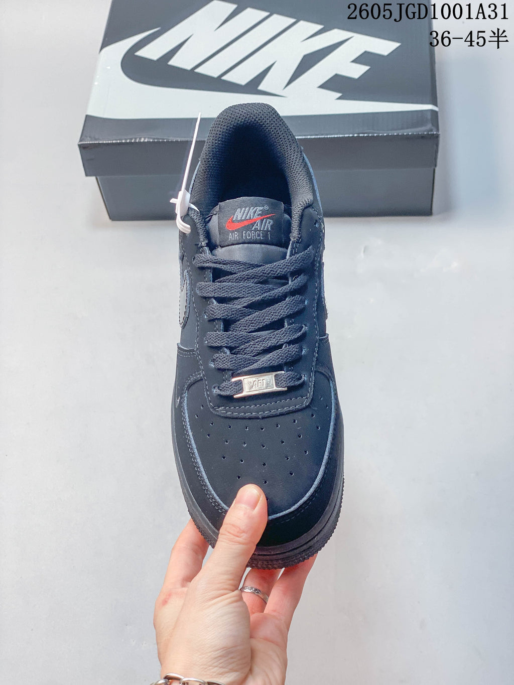 Front view showing the perforated toe, laces, and tongue label of a dark navy sneaker