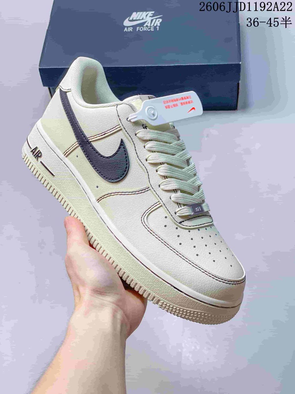 Close-up of a cream low-top sneaker with a dark swoosh and perforated toe