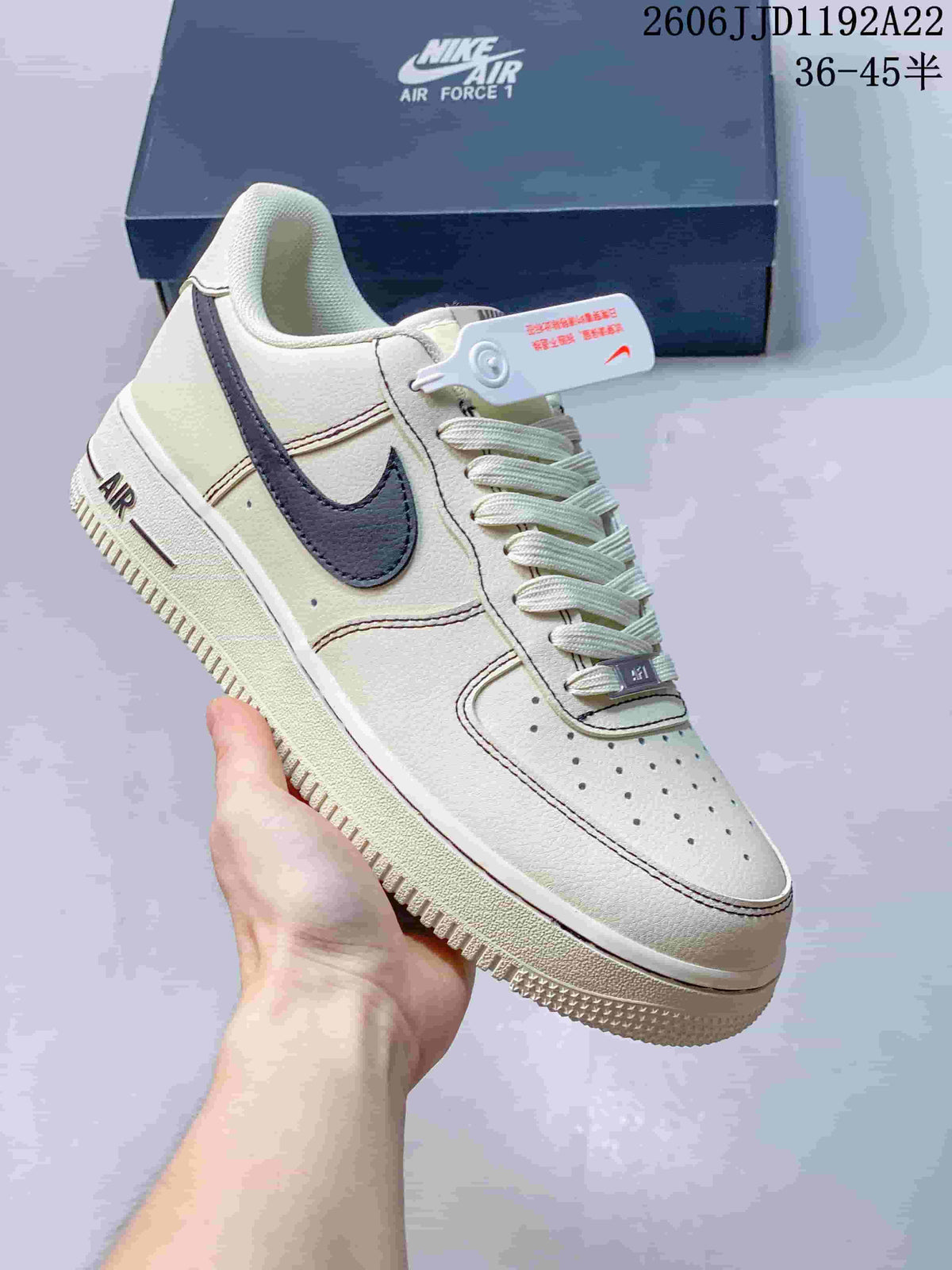 Close-up of a cream low-top sneaker with a dark swoosh and perforated toe