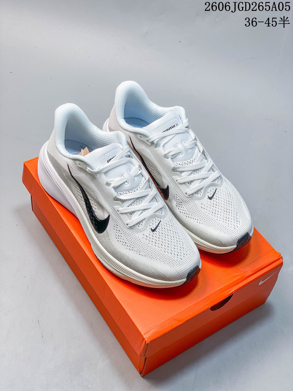 Pair of white Nike Pegasus 42 running shoes with dark accents, photographed on an orange shoebox.