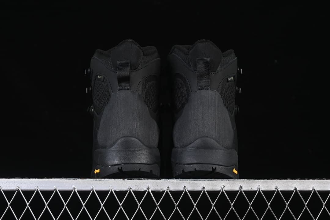 Rear view of a pair of black boots with lugged soles.
