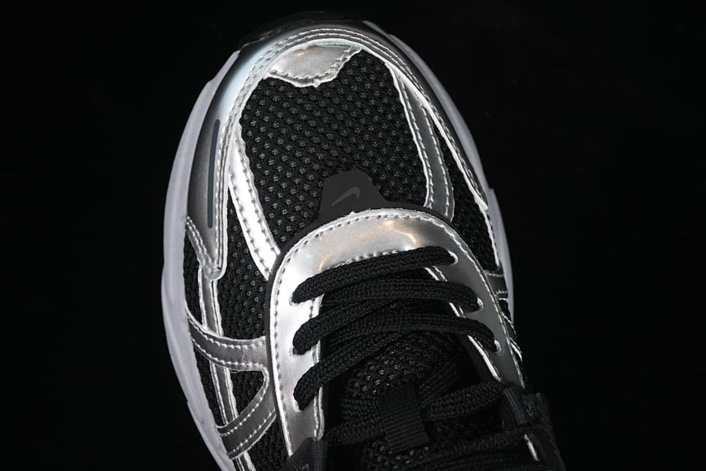 Top-down close-up of the black mesh toe and silver-toned overlays