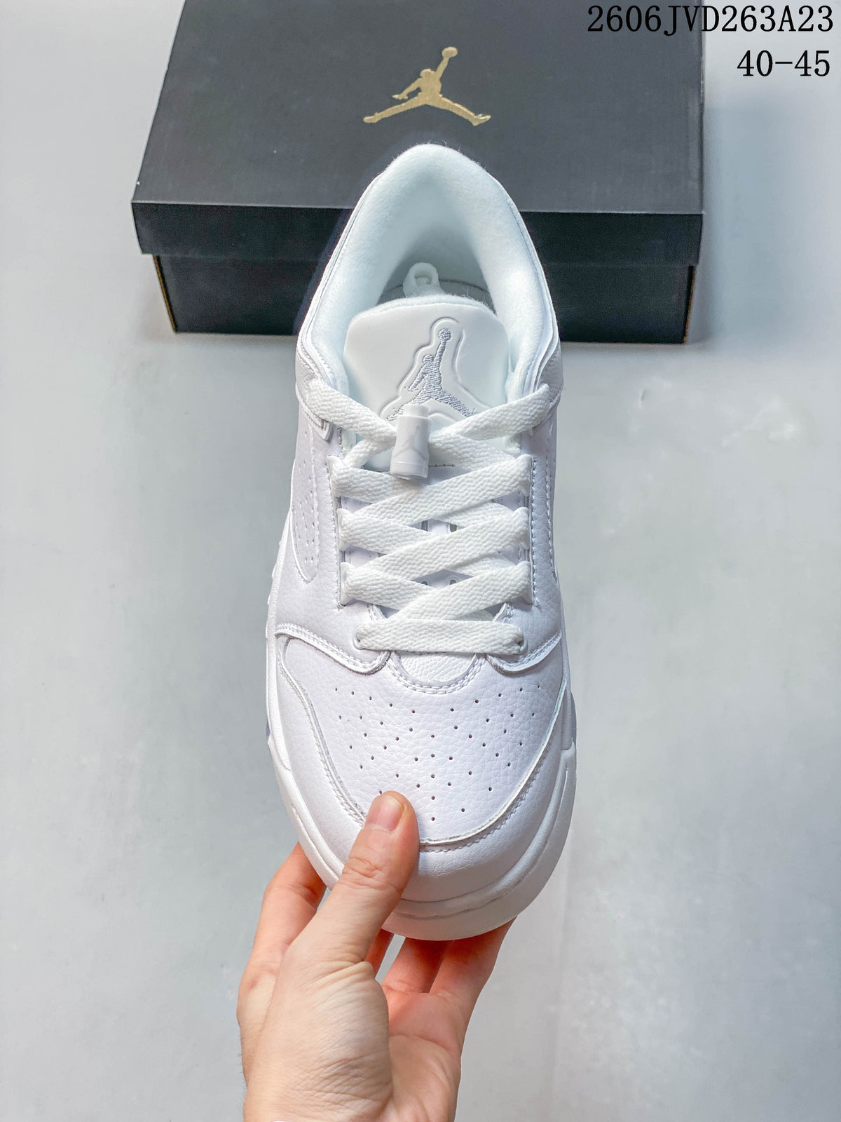 Top view of a white lace-up sneaker with perforated toe panels