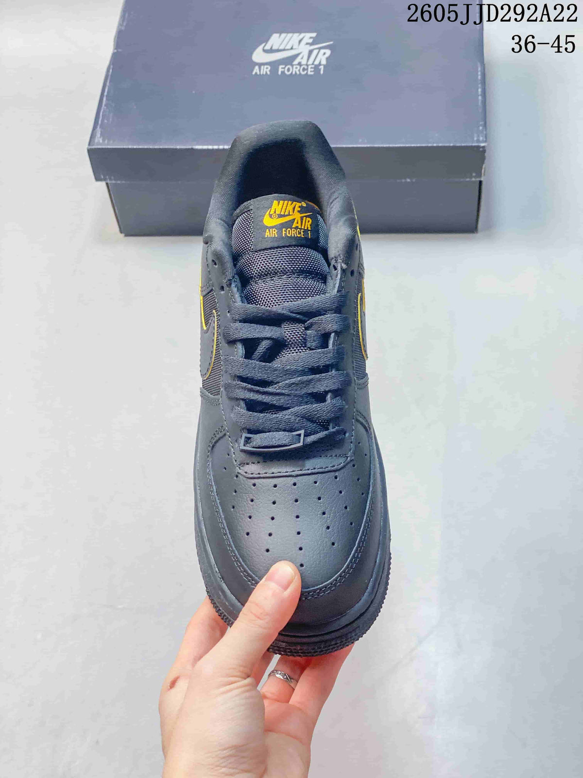 Front view of the gray sneaker showing perforated toe and yellow tongue detail