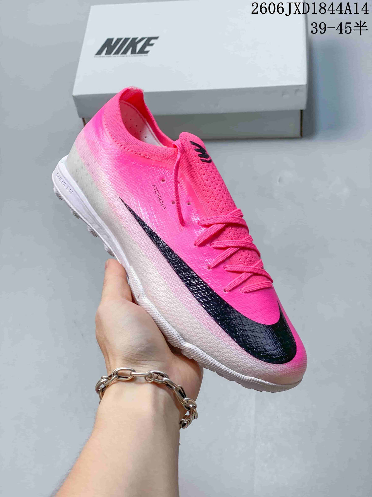 Angled side view of a pink Nike soccer cleat with black Swoosh details.