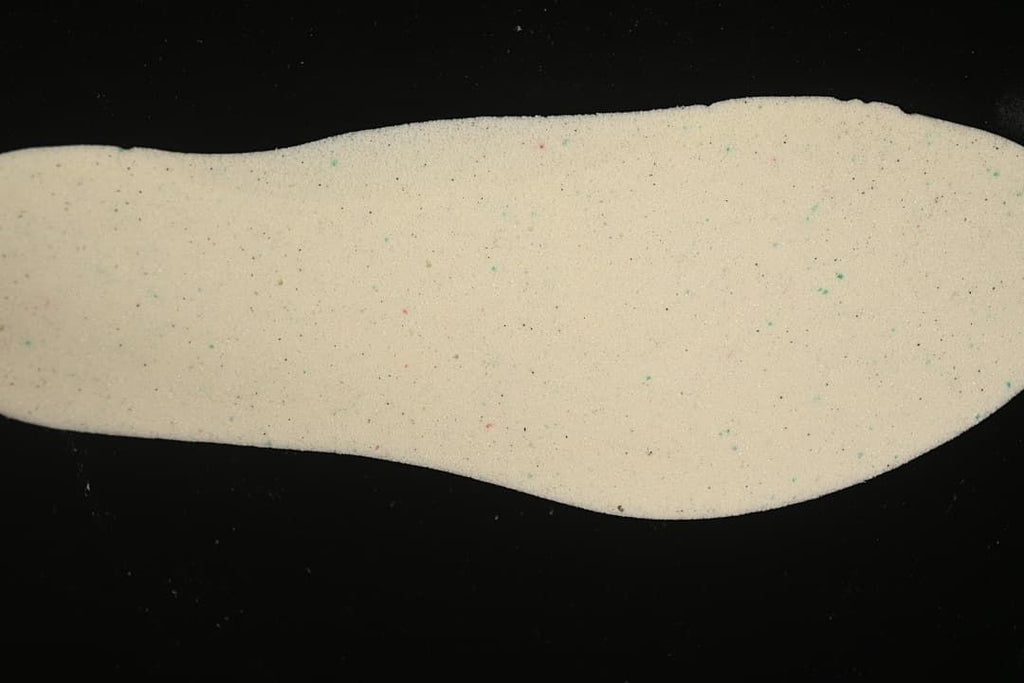 Light-colored shoe insole shown against a dark background