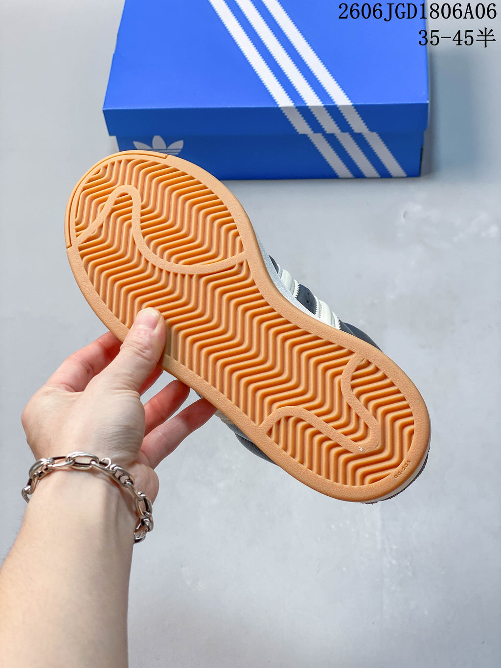Underside of a sneaker showing a gum-colored outsole with a zigzag tread pattern.