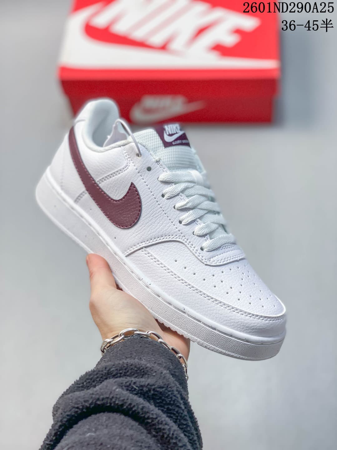 White low-top sneaker with burgundy accents and matching tongue label