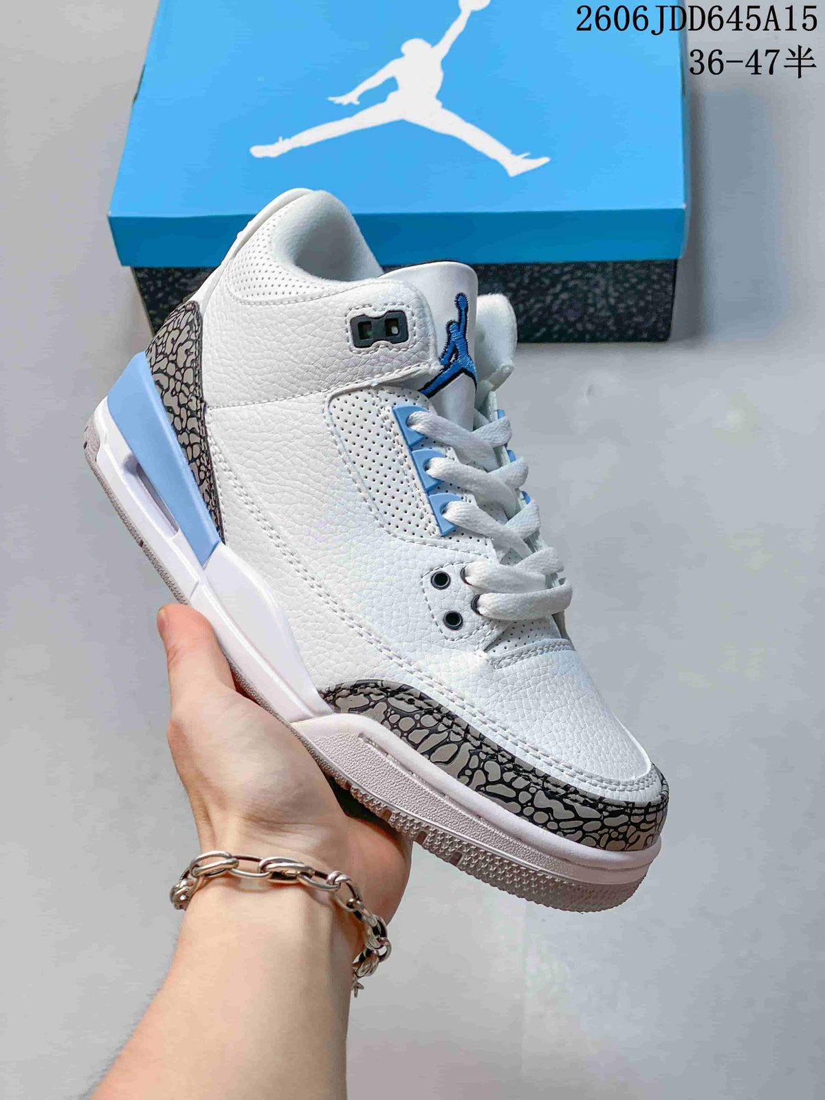 Angled side view highlighting the white upper, blue accents and patterned overlays.