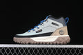 Side view of a light grey and tan Timberland mid boot with blue laces and a lugged outsole