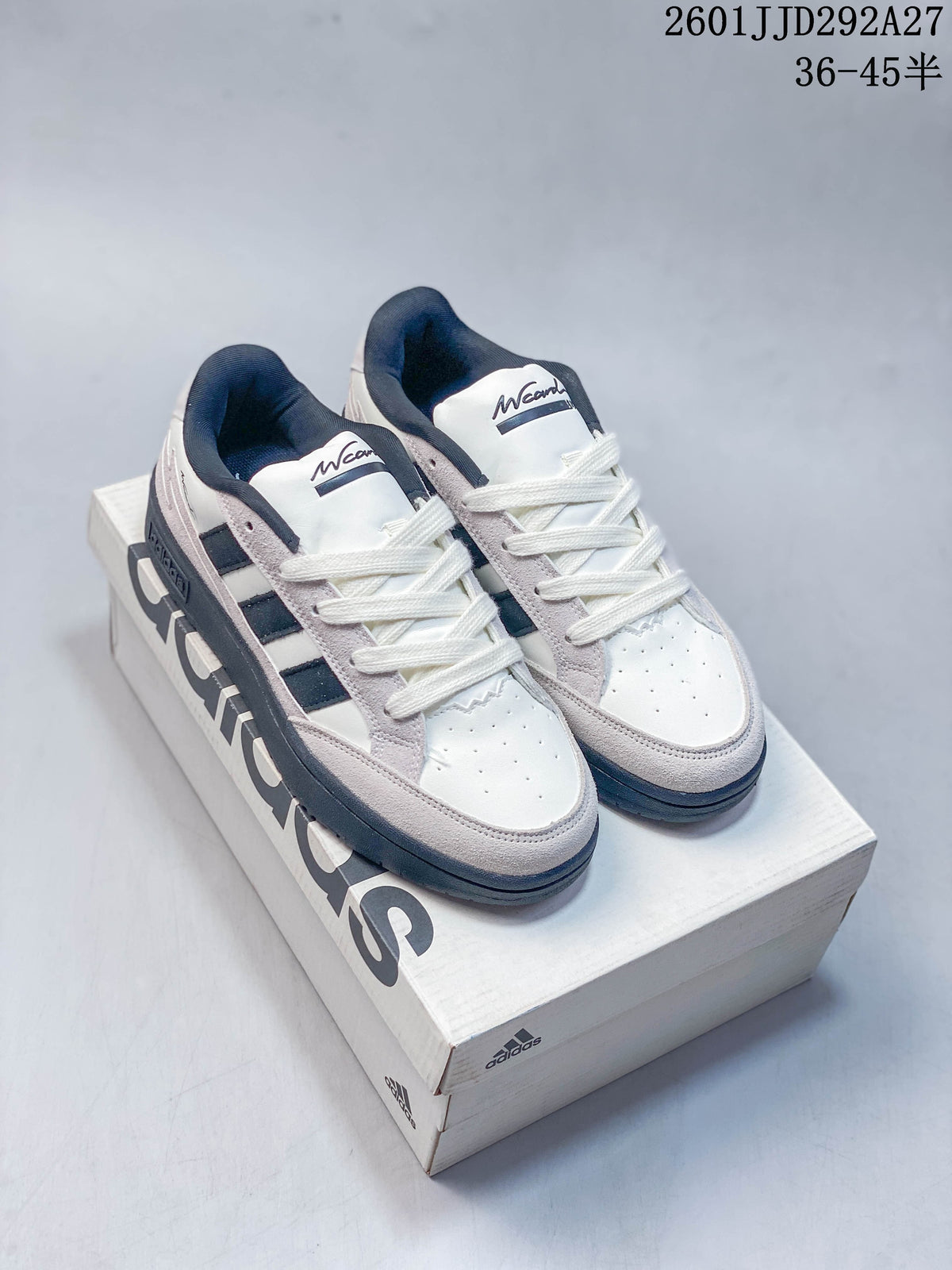 Pair of white Adidas Wcard Adv low-top sneakers with light gray overlays and dark stripes, shown on a shoebox