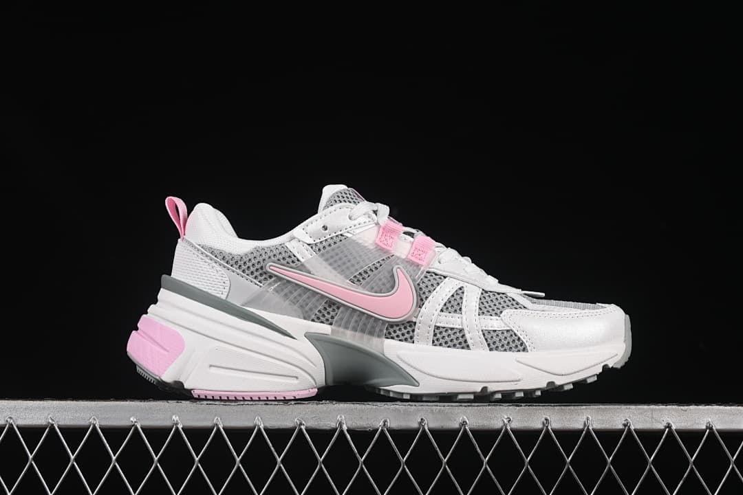 Side profile of a white and gray Nike V2K Run sneaker with pink accents