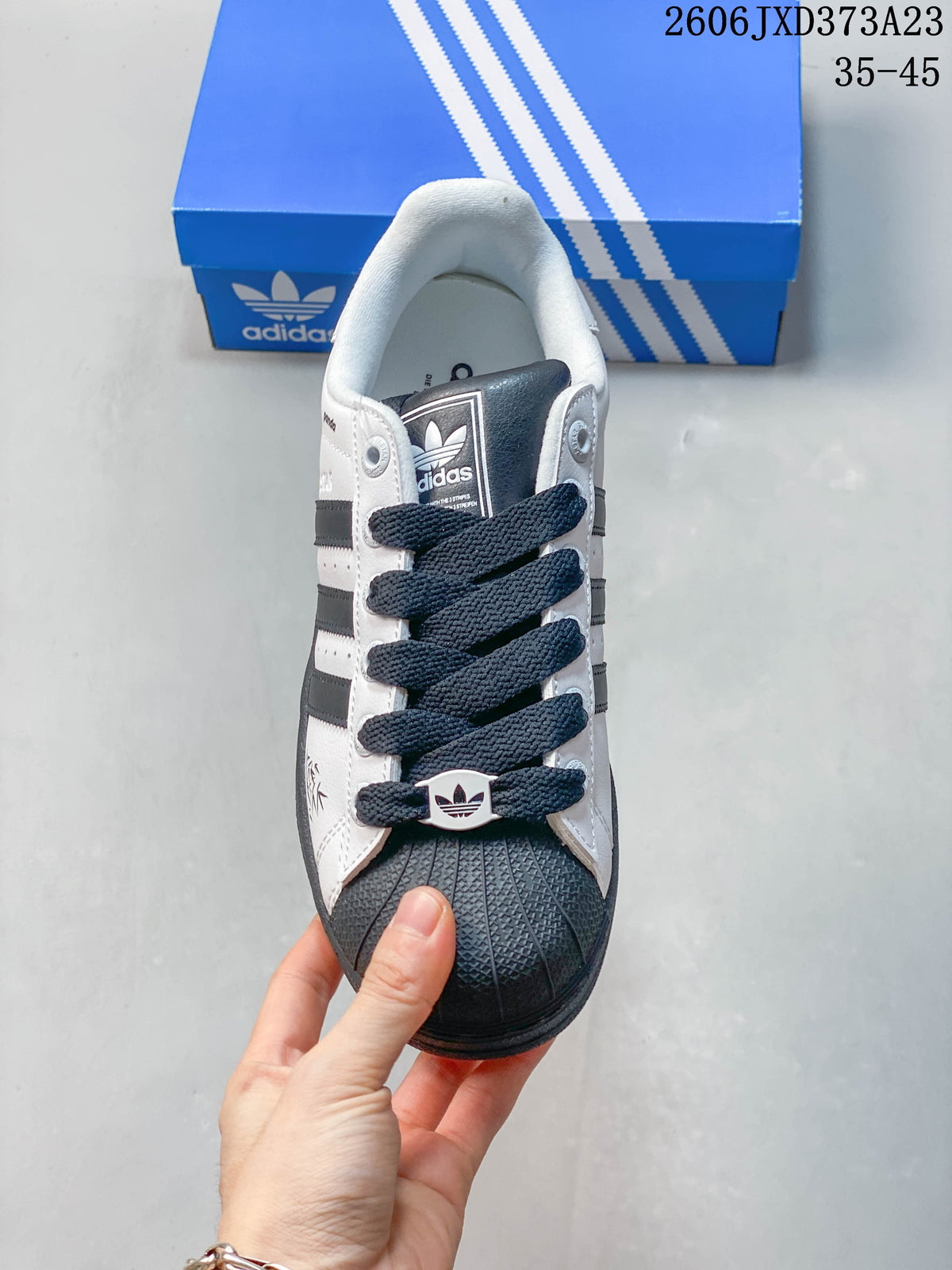 Front view of the Superstar sneaker showing its dark laces and textured shell toe.