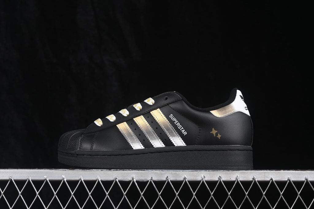 Side profile showing the Superstar lettering, metallic stripes, gold accents, and black sole.