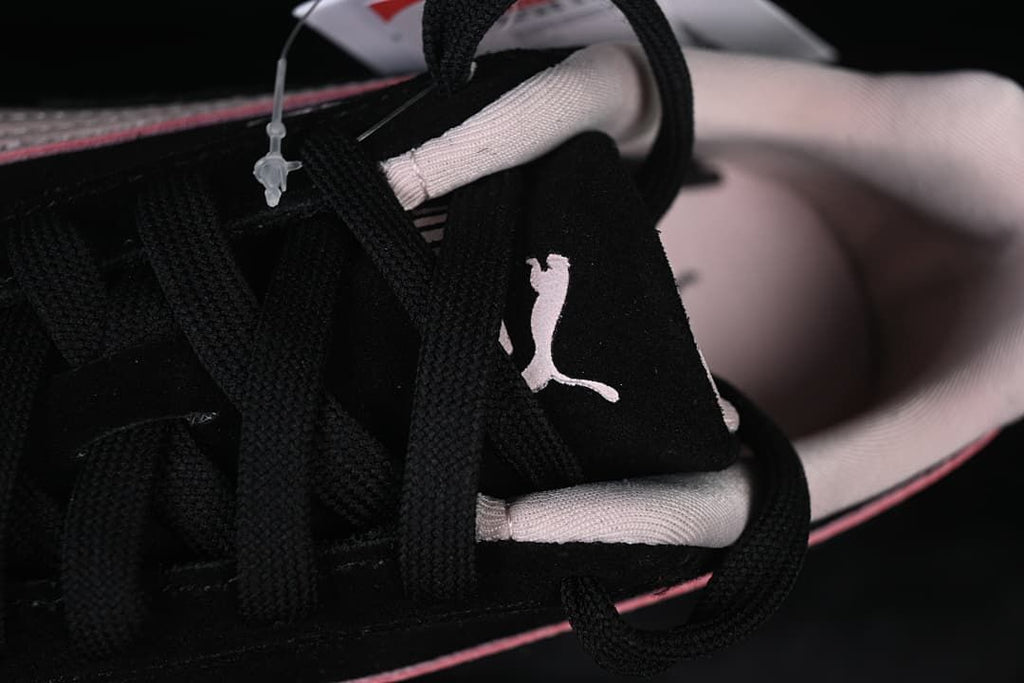 Close-up of black laces, tongue logo, and pale pink collar lining.