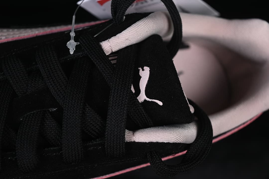 Close-up of black laces, tongue logo, and pale pink collar lining.