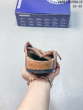 Rear view of a brown closed-toe clog with a textured outsole, shown in front of its shoe box.