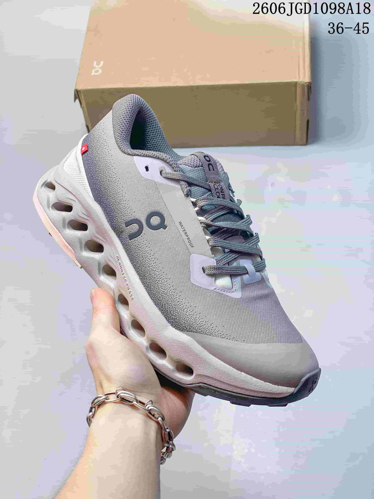 Angled side view of the gray and pale pink Cloudmonster 3 sneaker