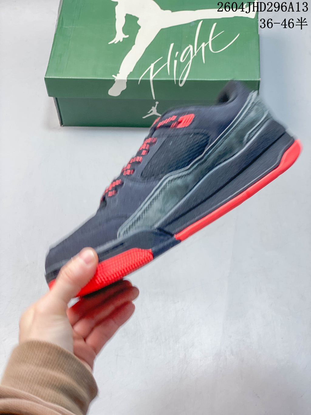 Side profile of a navy sneaker with gray side paneling and red outsole accents.