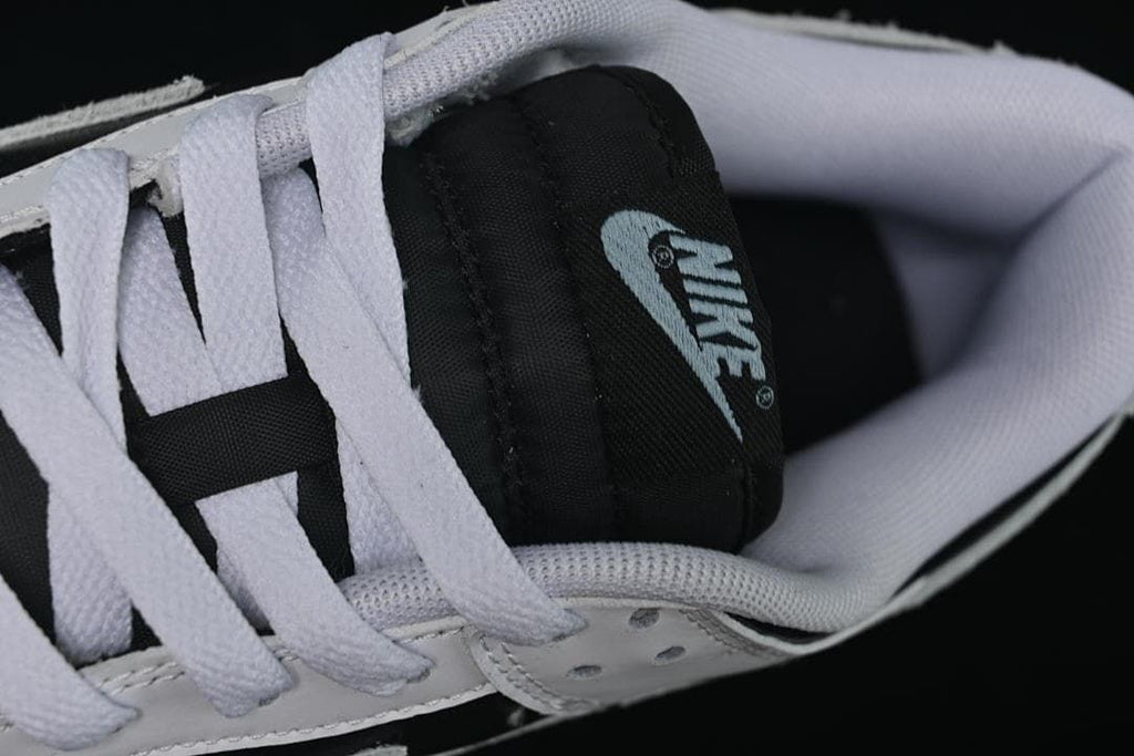 Top detail of the black tongue, white laces, and padded collar