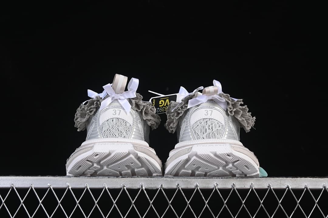 Rear view of both sneakers with textured outsole and ruffle trim