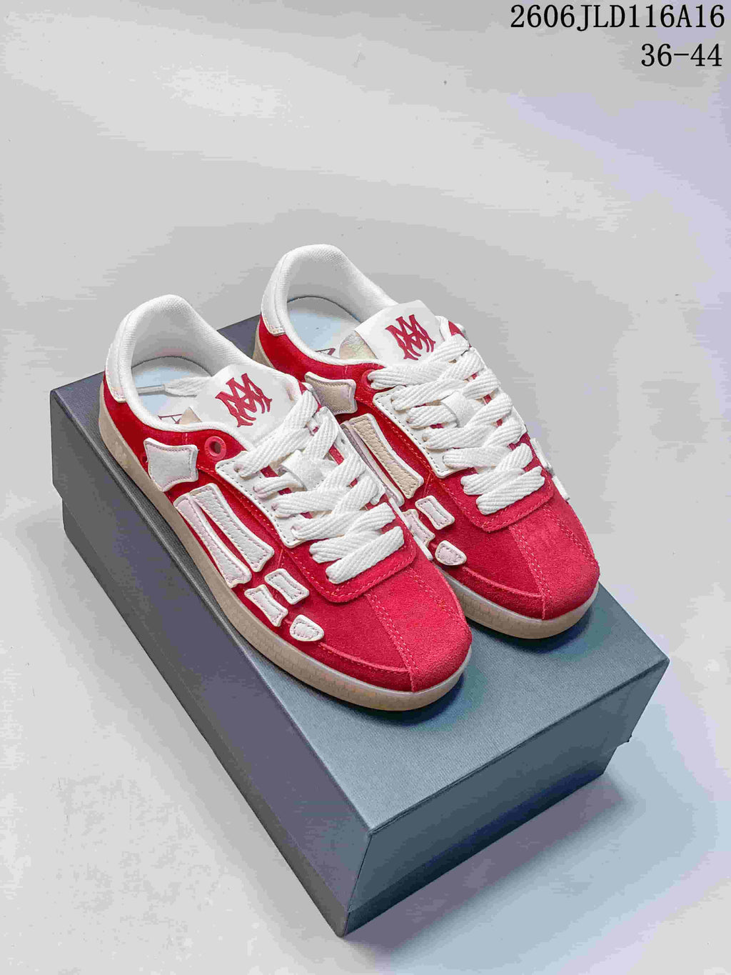 Pair of red and white AMIRI Pacific Bones low-top sneakers displayed on a box